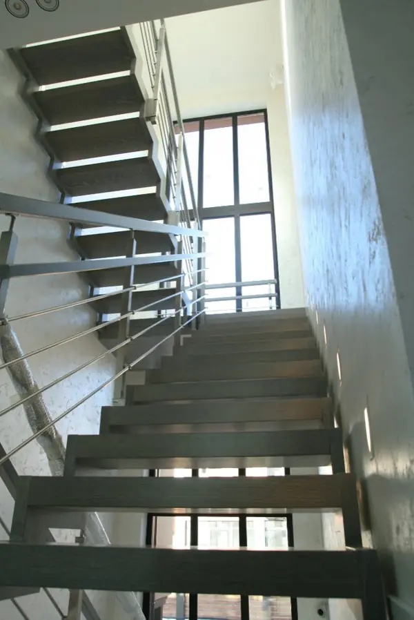 Modern metal stair covered by patina oak