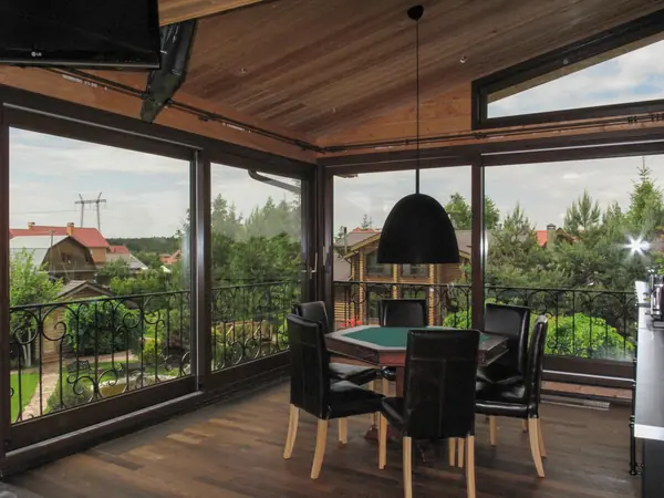 Панорамное остекление загородного дома окнами и порталами из сосны