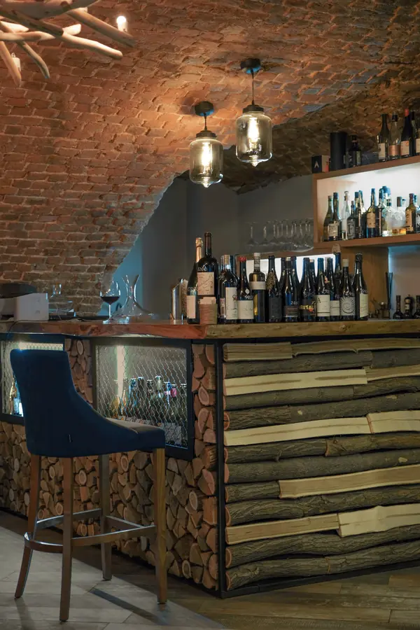 Винный погреб с барной стойкой из дров и камином