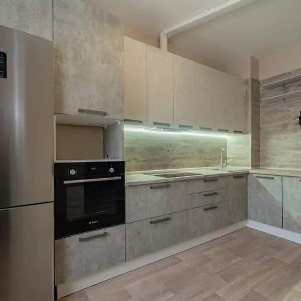 Угловая серо-белая кухня с современными ручками и фасадами под камень