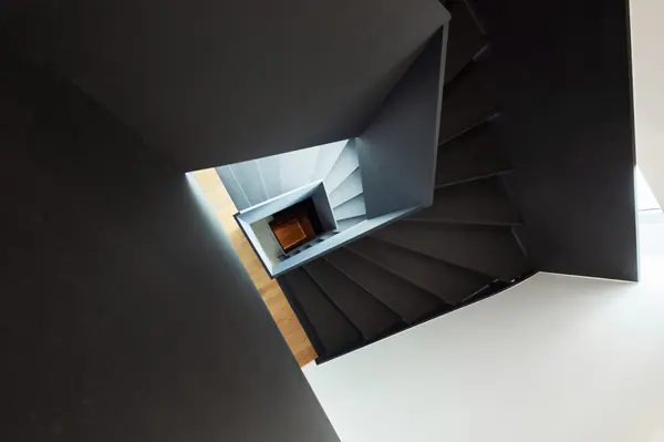 Черная лестница в проеме с окном