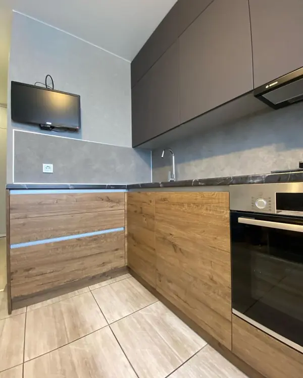 Угловая кухня в коричневом цвете с матовыми и древесными фасадами