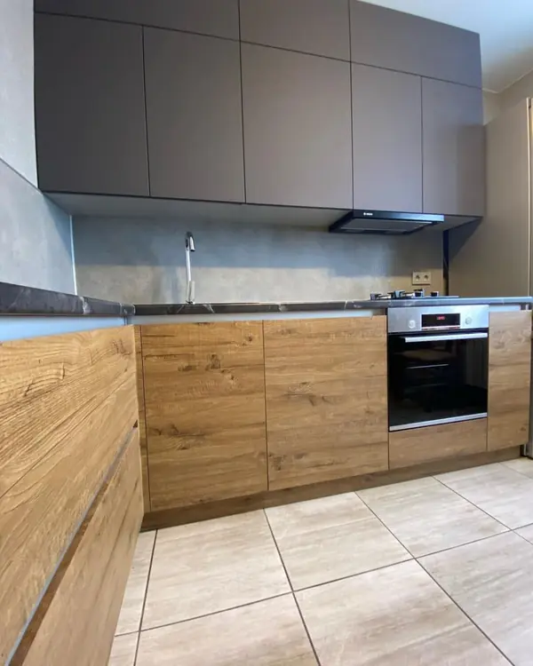 Угловая кухня в коричневом цвете с матовыми и древесными фасадами