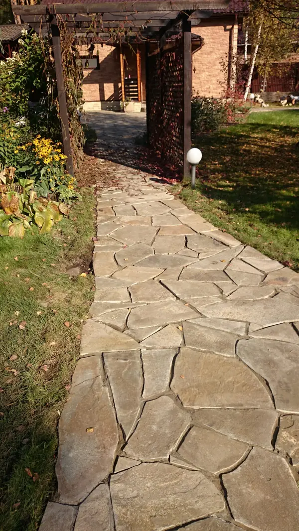 Элемент главной дорожки из натурального камня и деревянная пергола с виноградом