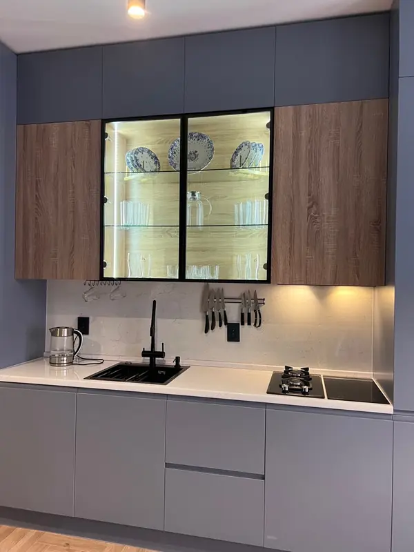 Прямая встроенная серая кухня со стеклянной витриной с подстветкой