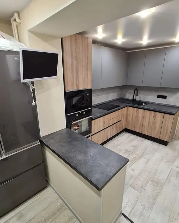 Стильная угловая кухня с деревянными и матовыми фасадами цвета графит