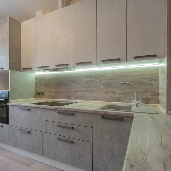 Угловая серо-белая кухня с современными ручками и фасадами под камень