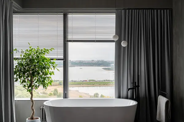 Бетонная квартира с ванной у окна