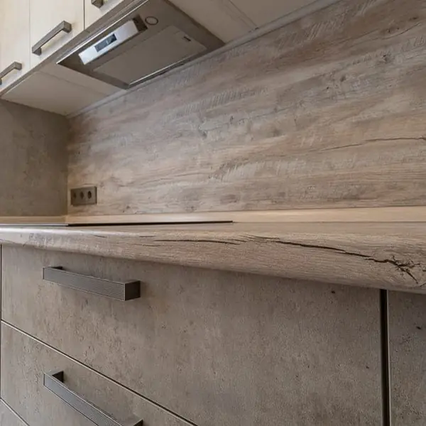 Угловая серо-белая кухня с современными ручками и фасадами под камень