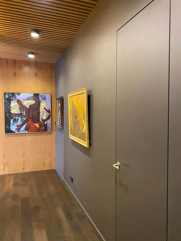 Скрытые двери в одном стиле со стеновыми панелями и реечное обрамление потолка