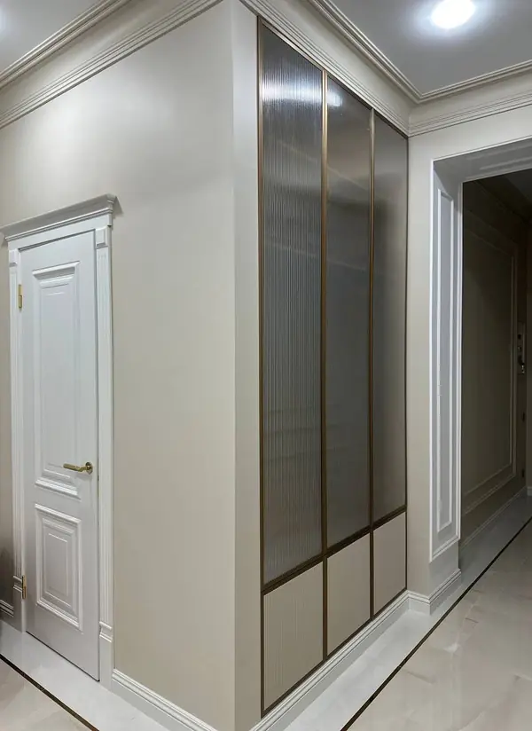 Шкаф в прихожую, интегрированный в стену, с алюминиевыми вставками и рифлением.