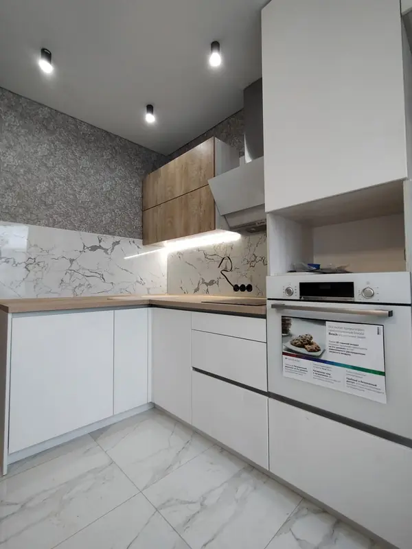 Светлая угловая белая кухня с горизонтальными верхними шкафами