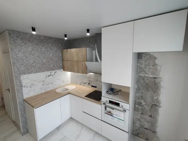 Светлая угловая белая кухня с горизонтальными верхними шкафами