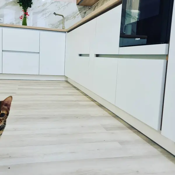 Уютная угловая кухня с фасадами под дерево и серыми матовыми фасадами