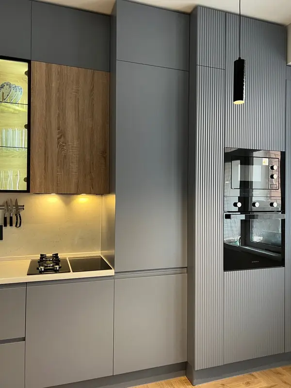 Прямая встроенная серая кухня со стеклянной витриной с подстветкой