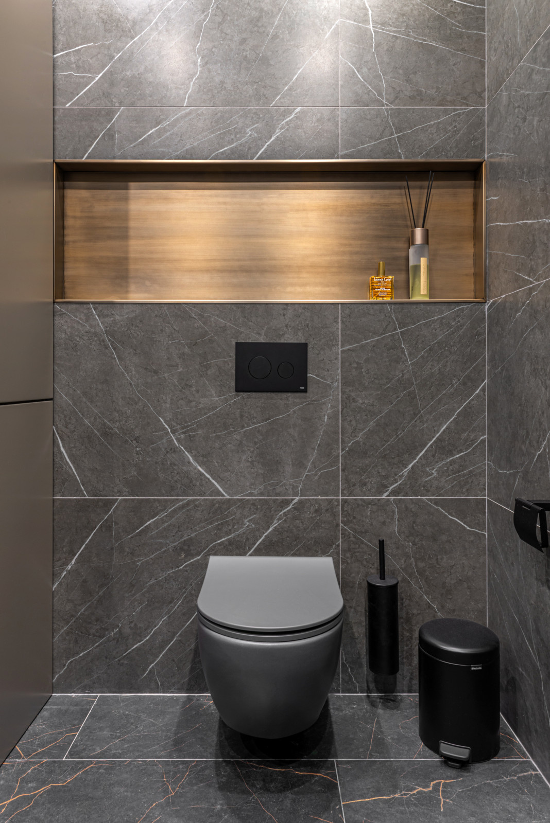 Компактный санузел с эффектной отделкой тёмным керамогранитом с мраморной фактур