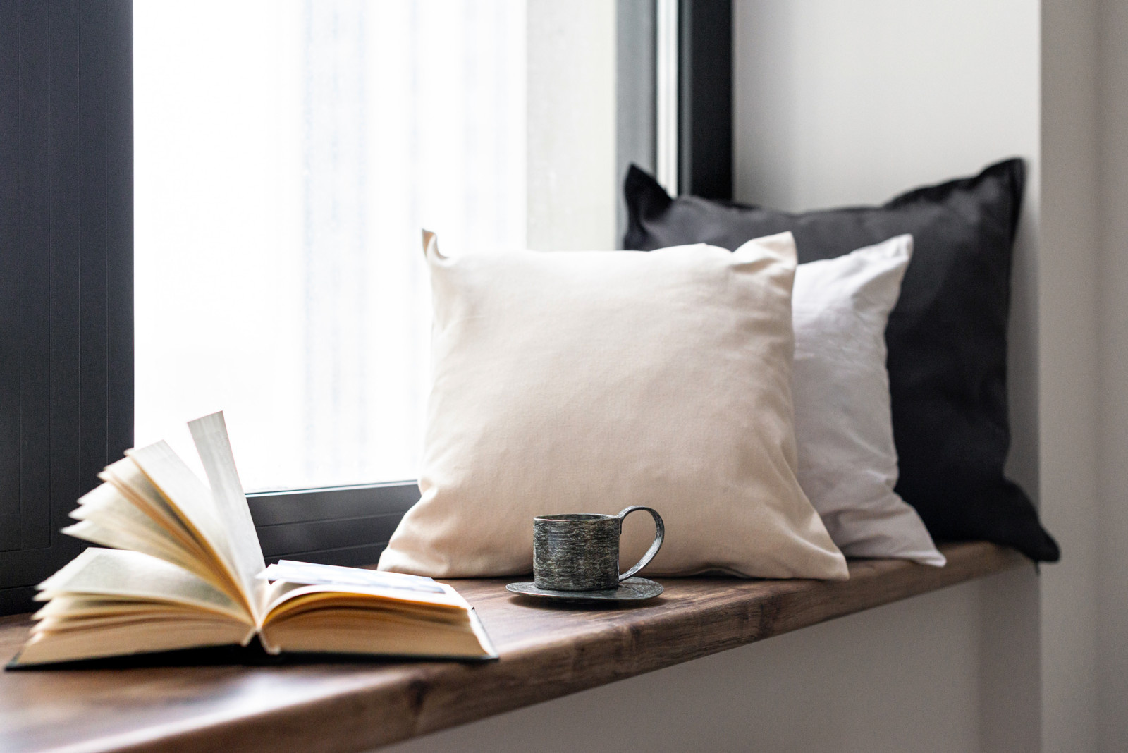 Зона отдыха на подоконнике с подушками и книгой