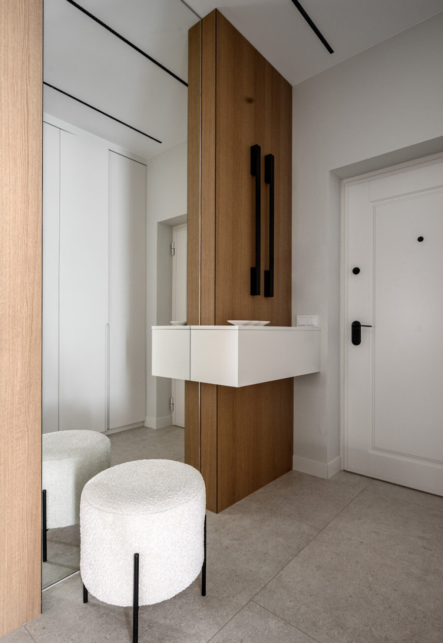 Зона прихожей с входной дверью, шкафом и зеркалом во всю стену