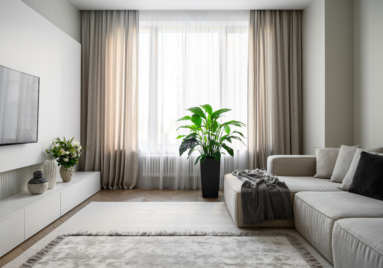 Светлая гостиная с мягким диваном и панорамными шторами в современном стиле