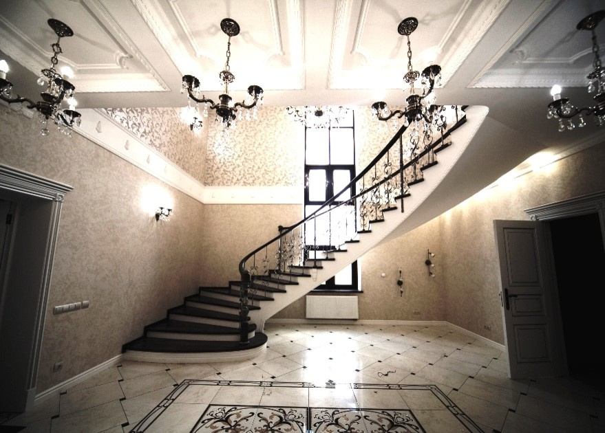 Бетонная лестница со ступенями из дуба и кованными балясинаями