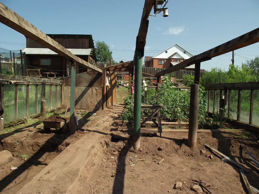 Из теплицы с помидорами в просторную беседку в бревенчатом стиле.