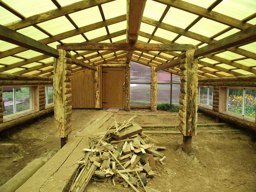 Из теплицы с помидорами в просторную беседку в бревенчатом стиле.