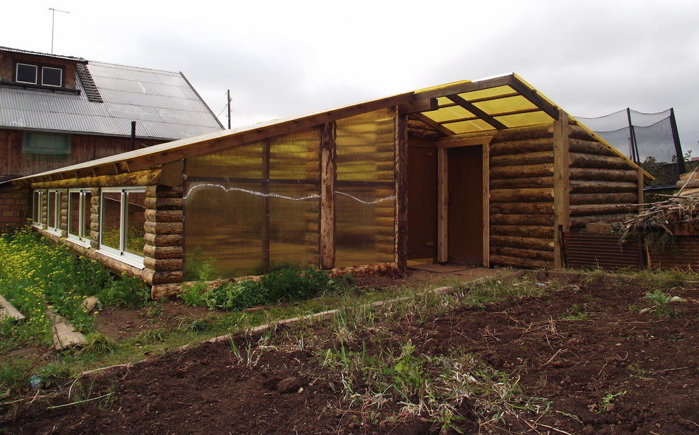 Из теплицы с помидорами в просторную беседку в бревенчатом стиле.