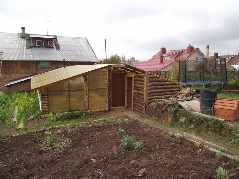 Из теплицы с помидорами в просторную беседку в бревенчатом стиле.