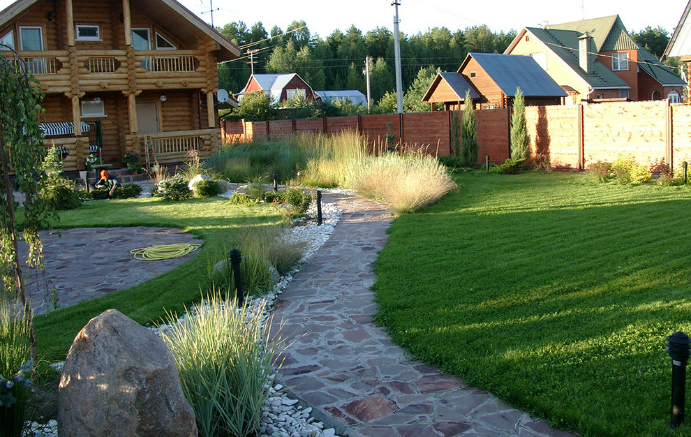 Сад трав, газон и дорожка из натурального камня.