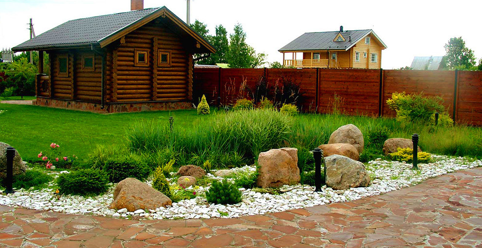 Злаковые травы, гравий и камни в дизайне участка.