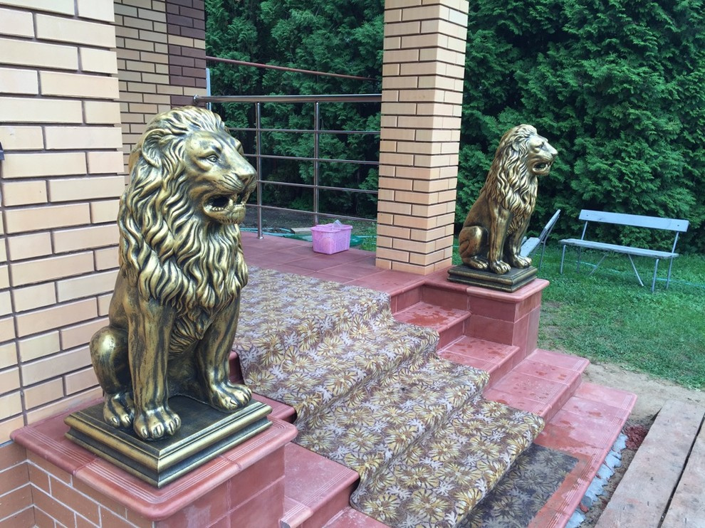 Скульптуры бетонных львов в золотом цвете на главной лестнице