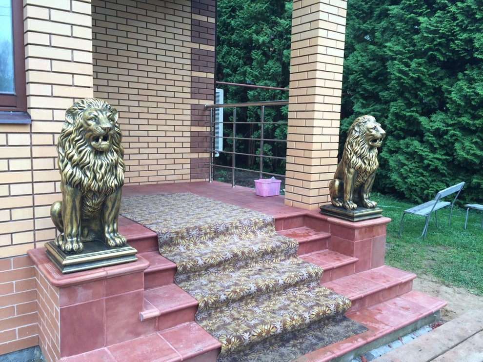 Скульптуры бетонных львов в золотом цвете на главной лестнице