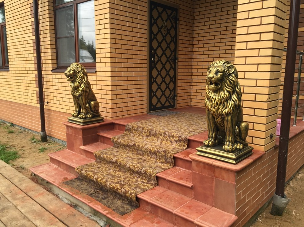 Скульптуры бетонных львов в золотом цвете на главной лестнице