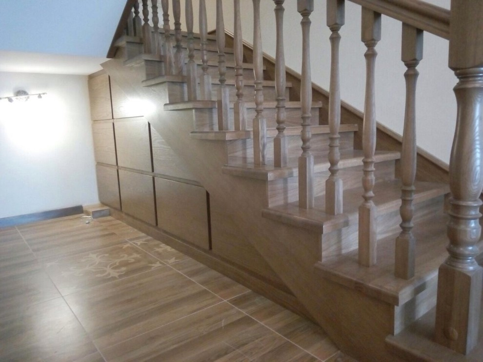П-образная монолитная лестница с площадкой, в отделке дубом