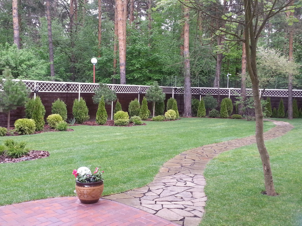 Сад с хвойниками и большим количеством газона