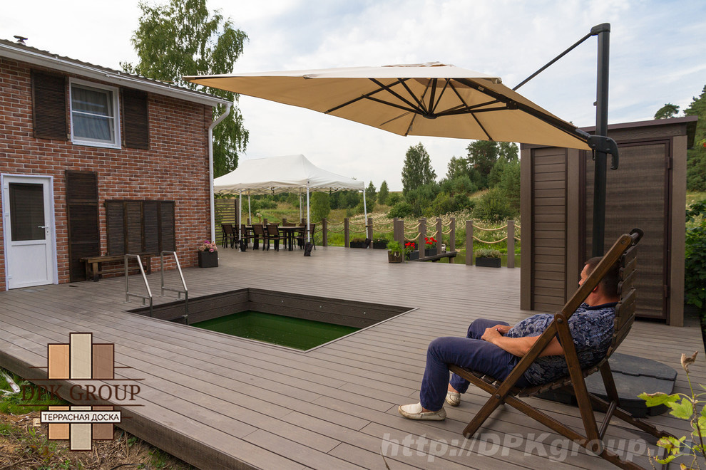 Терраса с баней на склоне берега пруда.