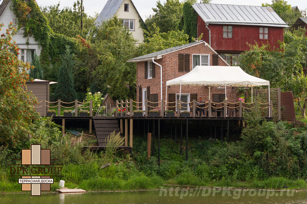 Терраса с баней на склоне берега пруда.