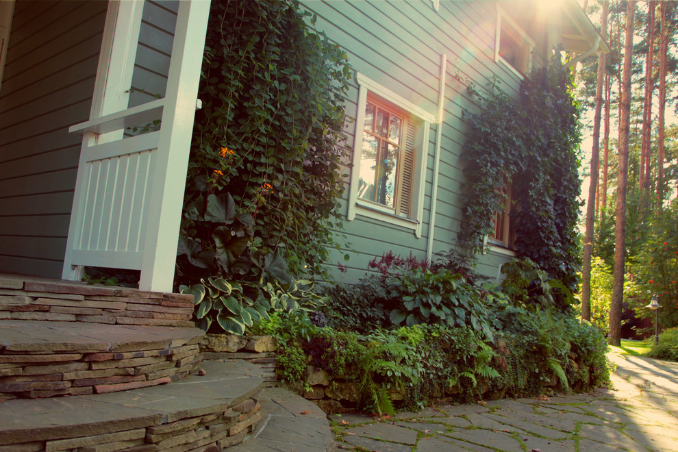 Цветник на подпорной стенке вдоль дома