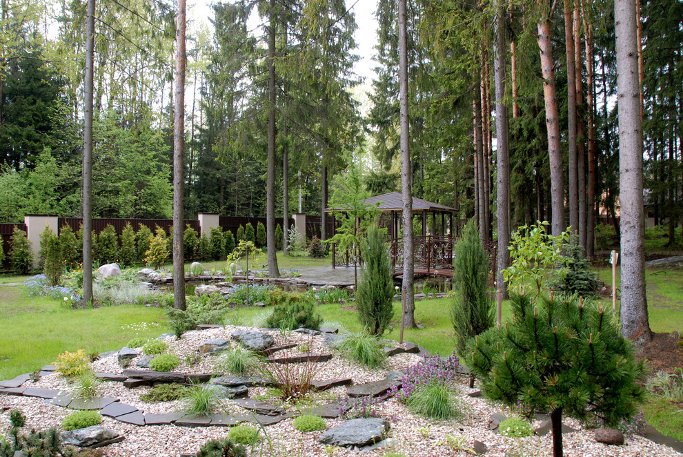 Вид на водоем от дома через каменистую композицию