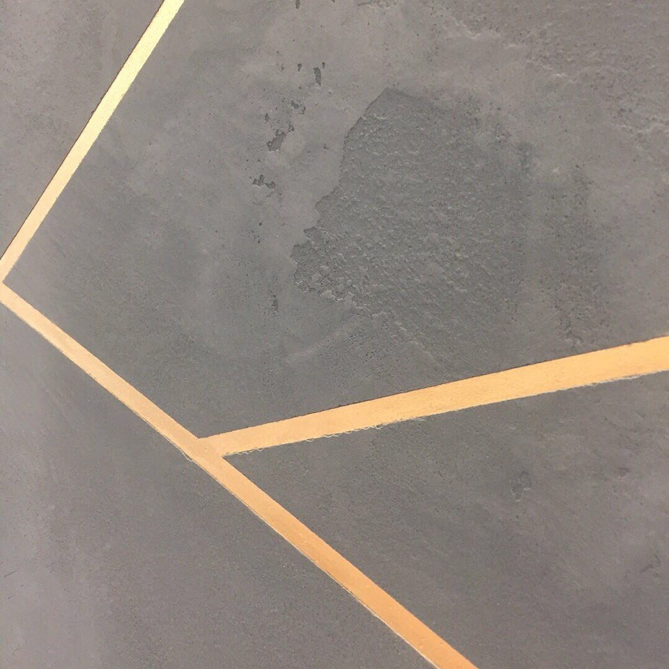 Сочетание золота и геометрии на цементной фактуре