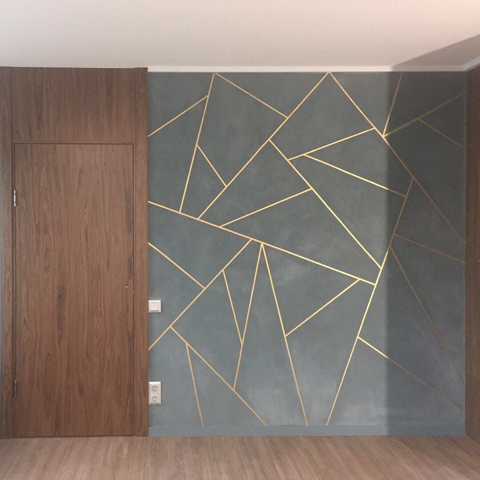 Сочетание золота и геометрии на цементной фактуре