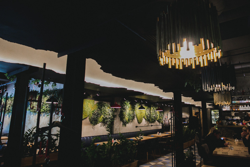 Металлическая аркада, вешалки с красными крюками, люстры из латуни и из стали