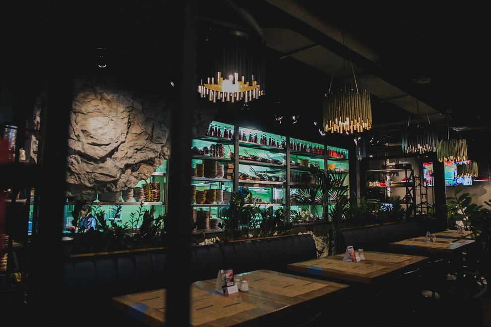 Полки-перегородка между кухней и залом из нержавейки, люстры из латуни и стали