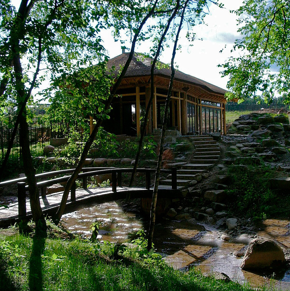 Павильон с соломенной крышей и сад у реки