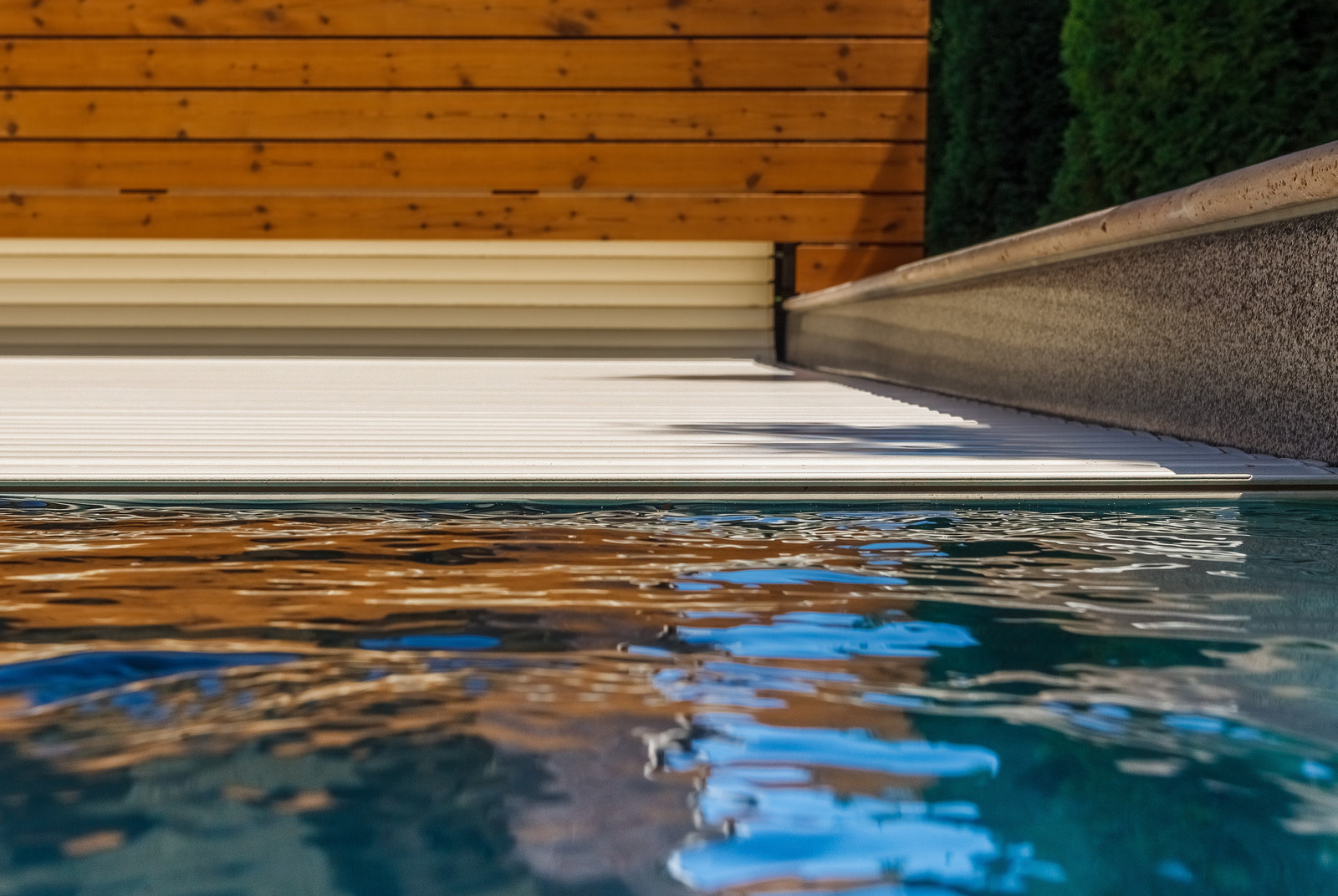 Роллетное покрытие для бассейна под декоративным деревянным коробом.
