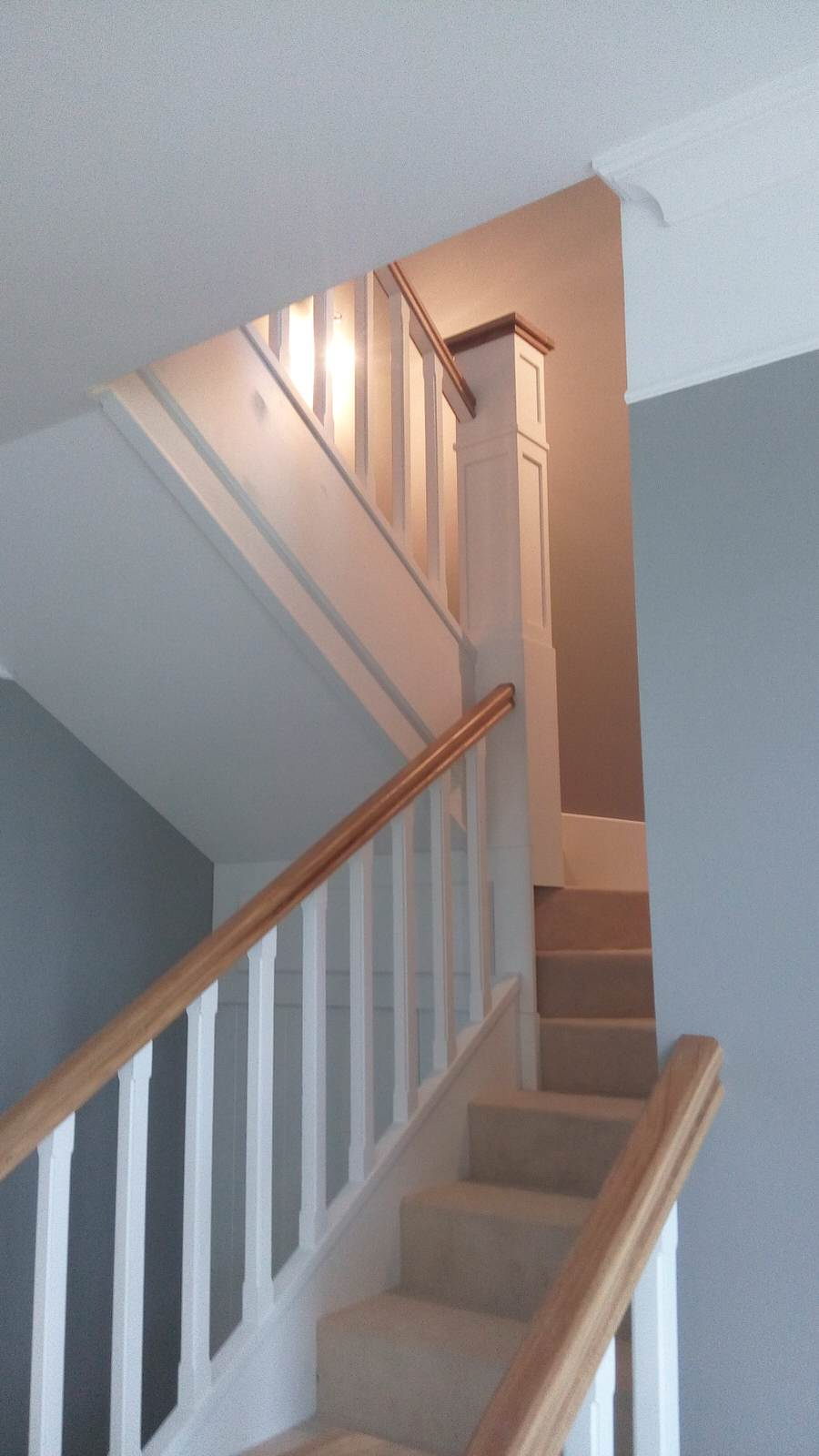 Белая лестница с ковролином и столбами-колоннами