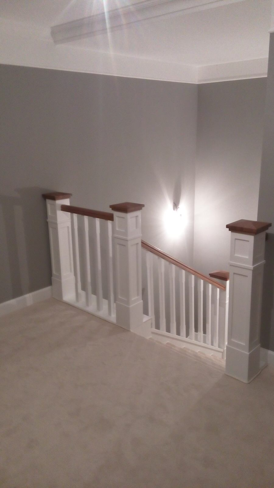 Белая лестница с ковролином и столбами-колоннами