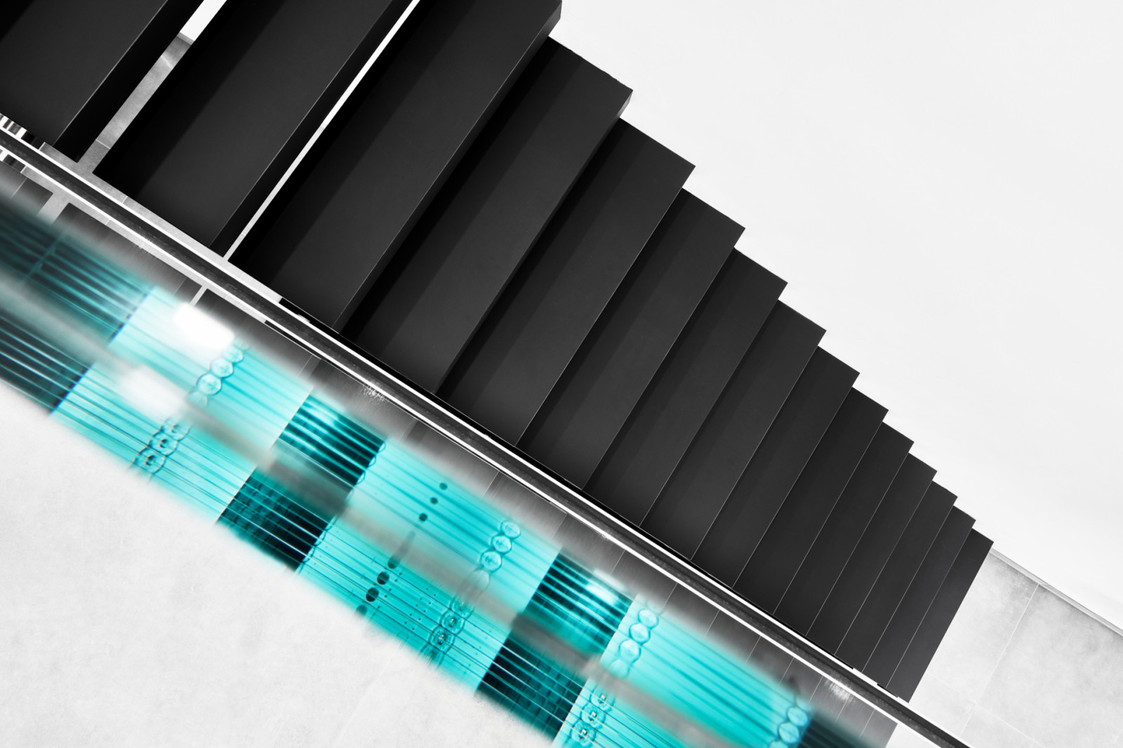 Консольная лестница в черном матовом цвете с ограждением из белого стекла