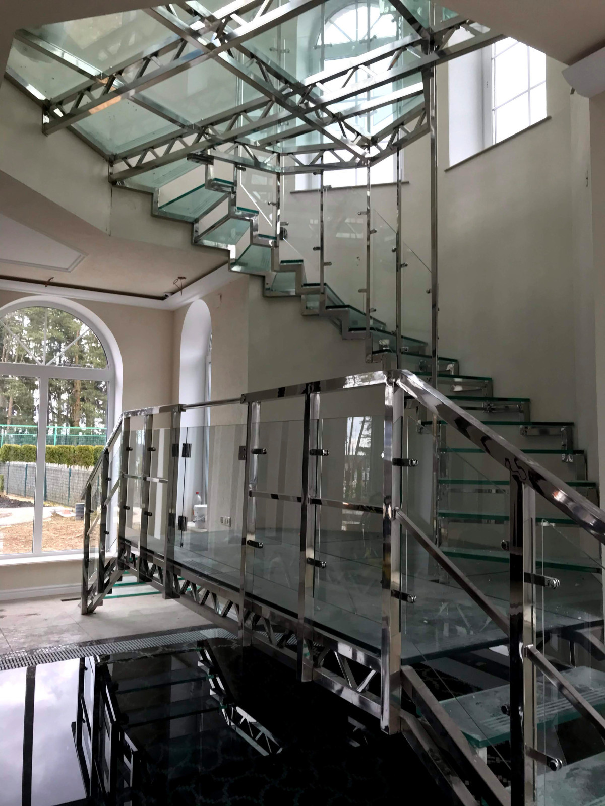 Винтовая стеклянная лестница над бассейном