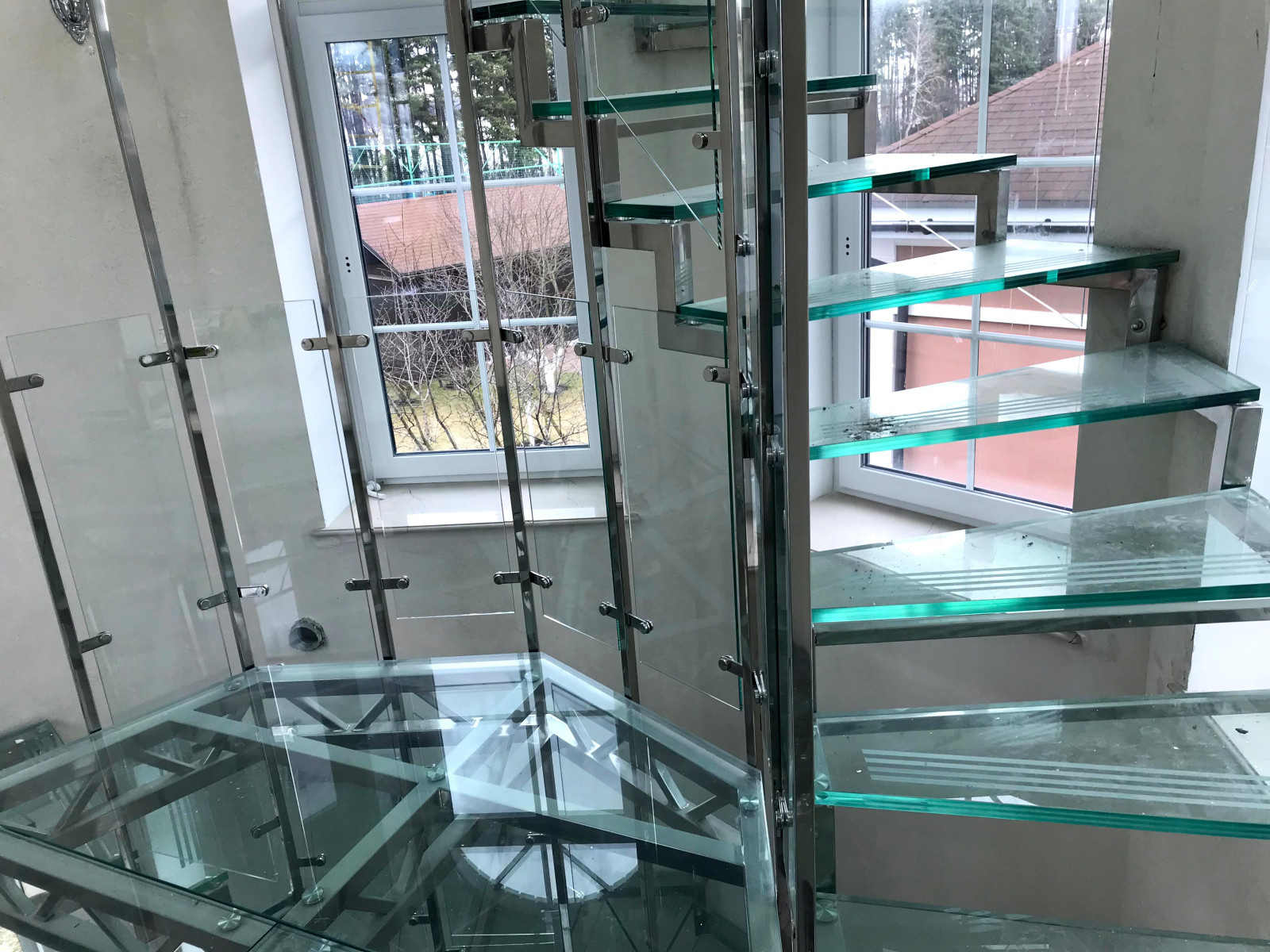 Винтовая стеклянная лестница над бассейном